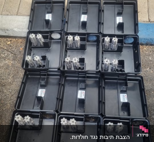 תיבות האכלה שחורות פתוחות המכילות פתיונות רעל להדברת מכרסמים